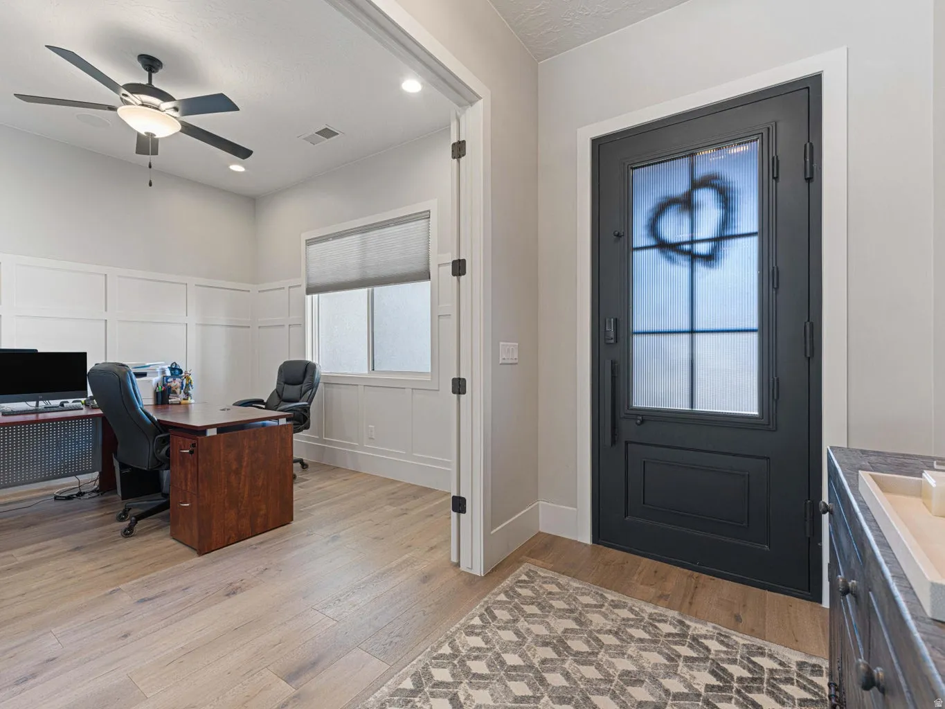 Black entry door with window grid and transom window