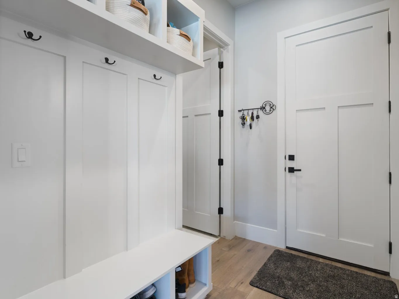 Entryway featuring a built-in bench, overhead shelving, and wall hooks