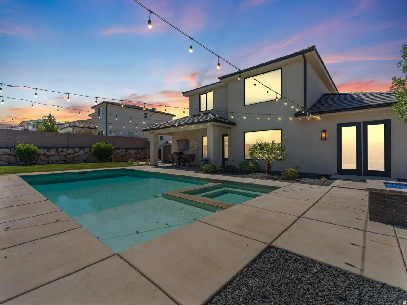 Expansive backyard featuring a large swimming pool, integrated spa, and paved patio