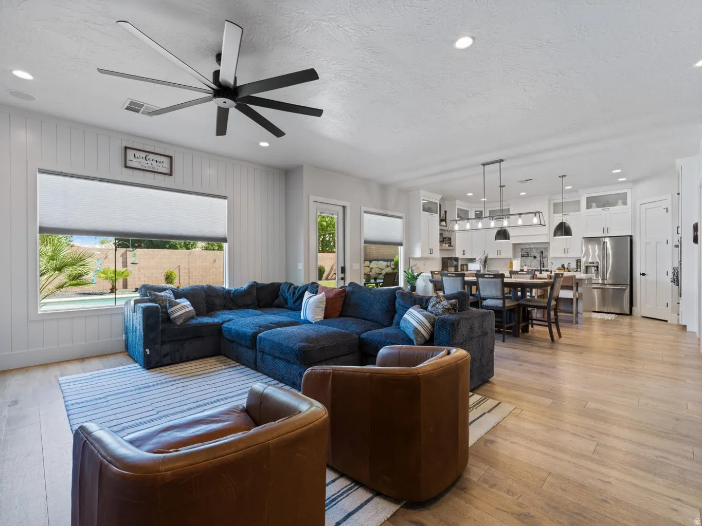 Open-concept living space featuring wood-finish flooring, recessed lighting, and a modern ceiling fan