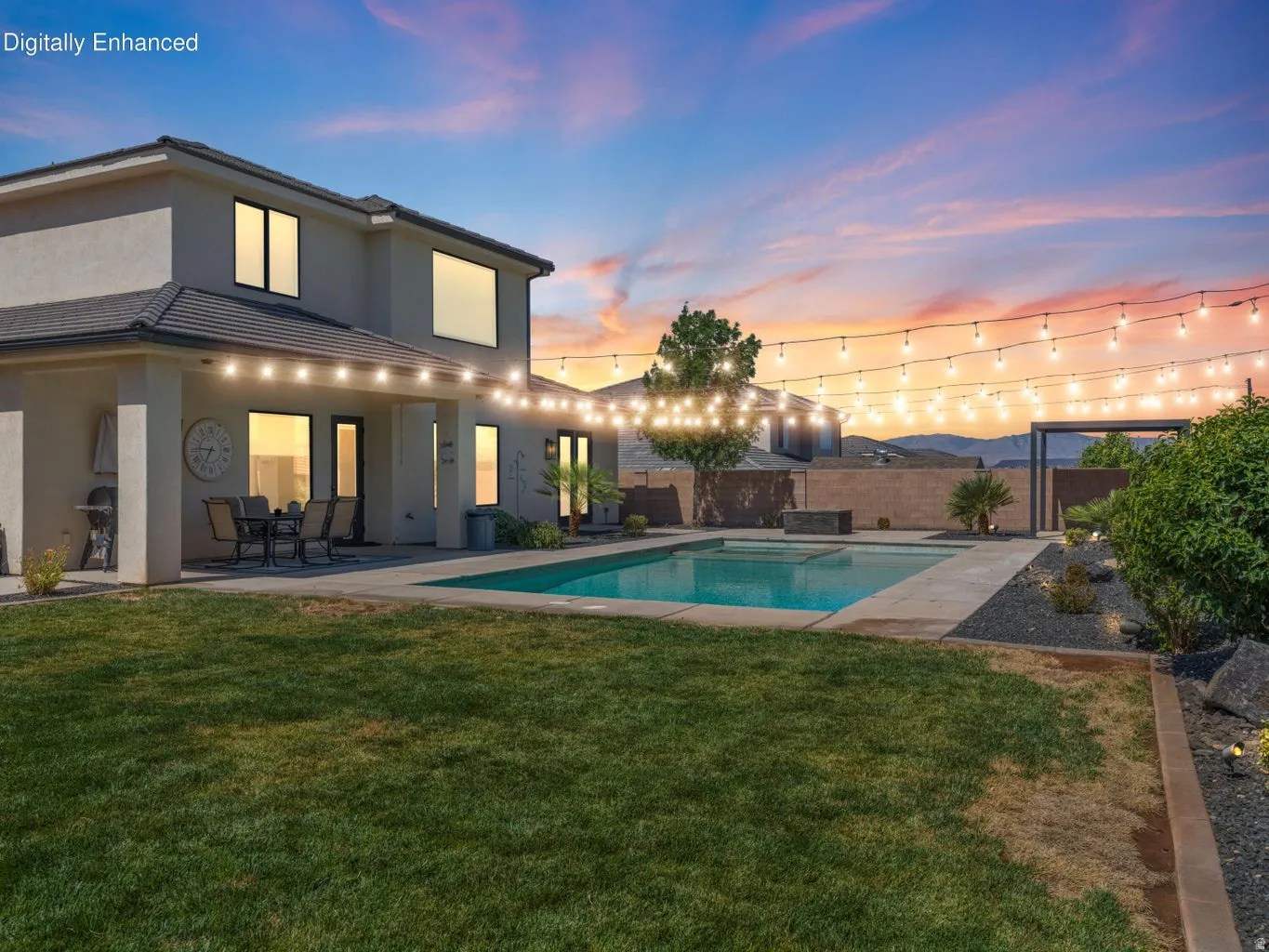 Expansive outdoor living area featuring a rectangular swimming pool, a covered patio, and a manicured lawn