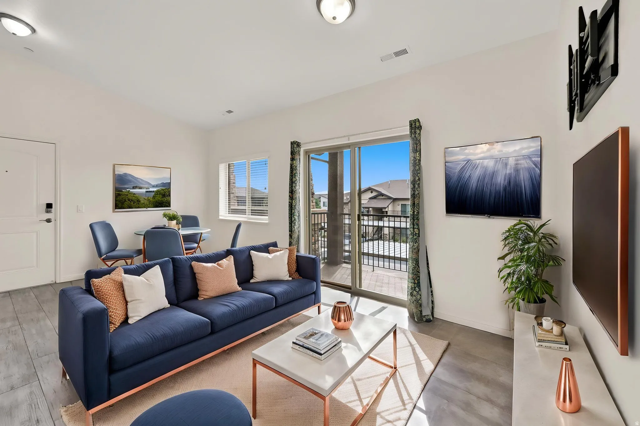 Wood-finish flooring, white walls, recessed lighting, and a sliding glass door to a balcony with black railings