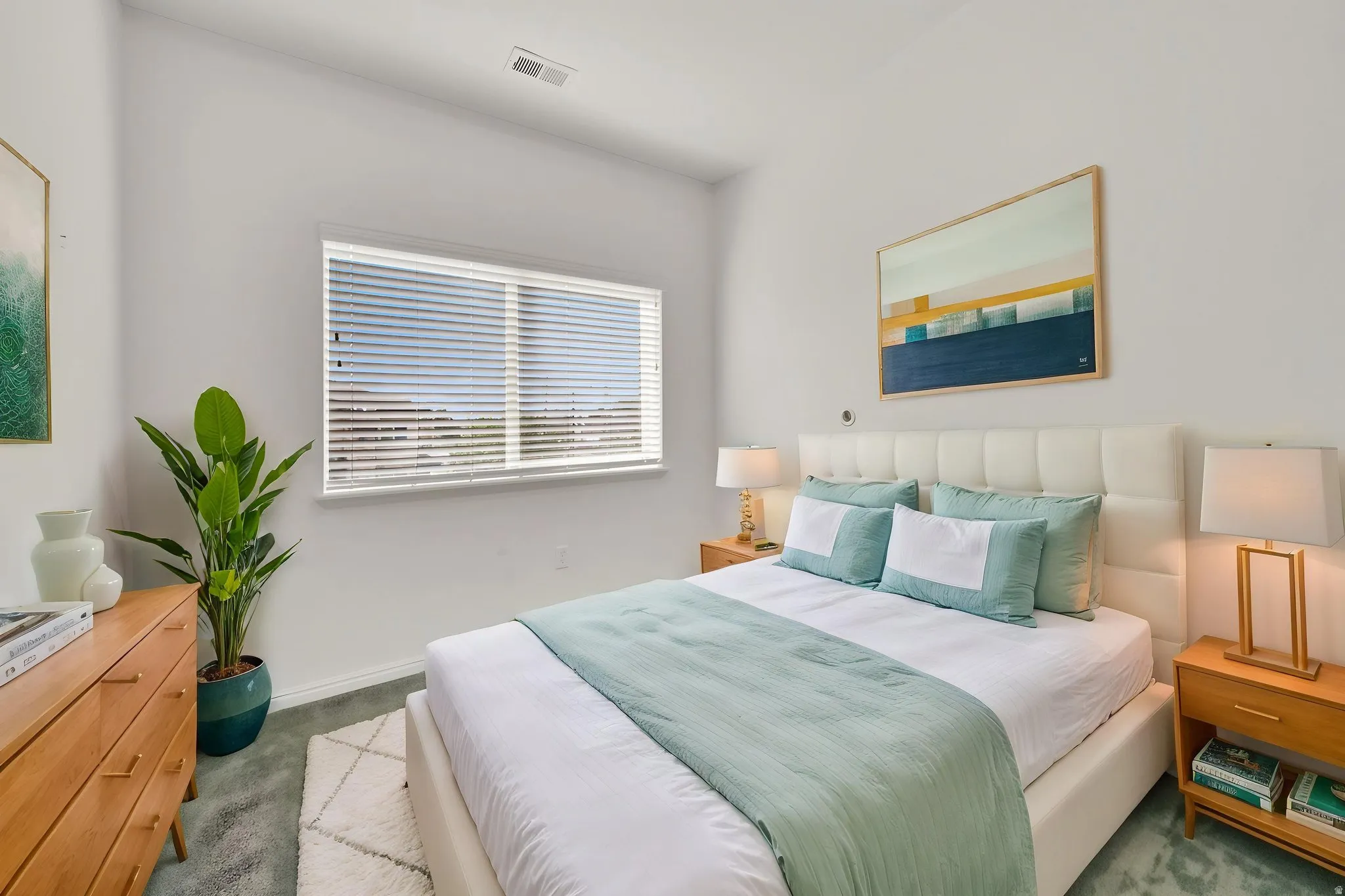 White upholstered headboard, a window with blinds, light wall paint, recessed lighting, and soft-toned carpeting