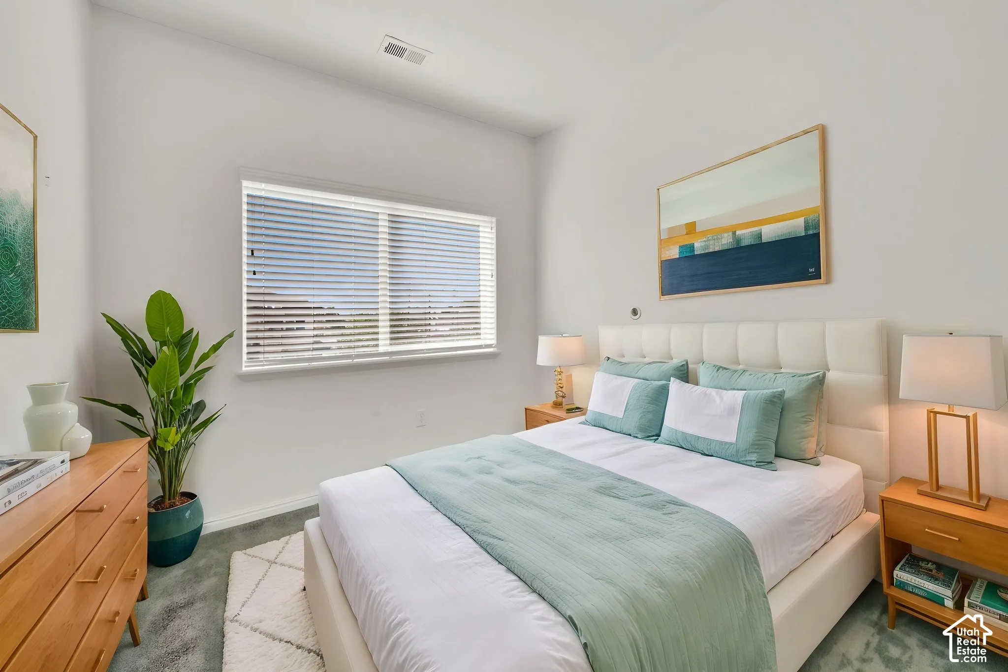 White upholstered headboard, a window with blinds, light wall paint, recessed lighting, and soft-toned carpeting