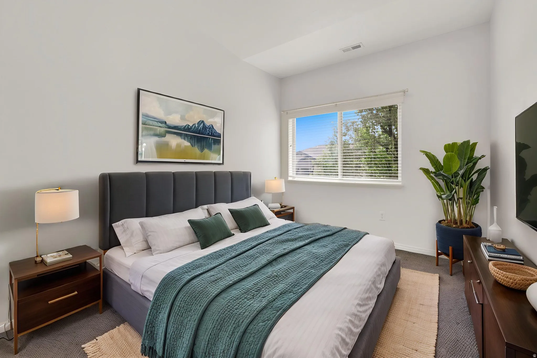 Recessed lighting, large window with blinds, plush gray carpeting, and white walls