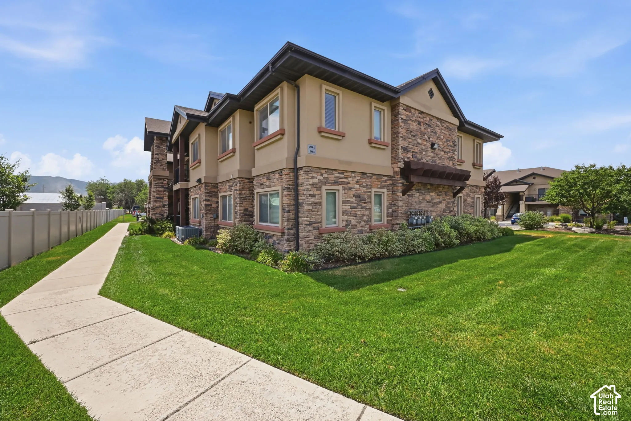 Multi-story residential building featuring stone and stucco exterior finishes