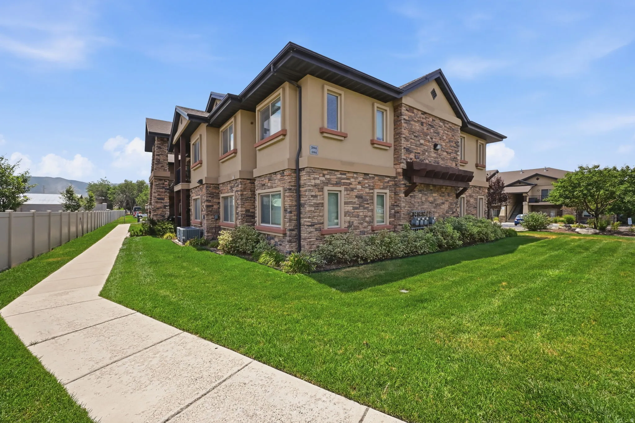 Multi-story residential building featuring stone and stucco exterior finishes