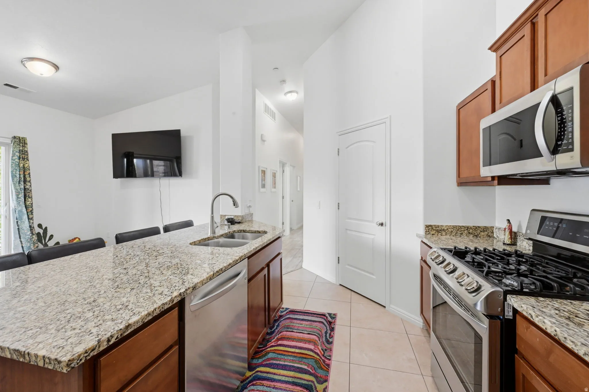 Kitchen featuring a gas range, stainless steel microwave, and wood cabinetry