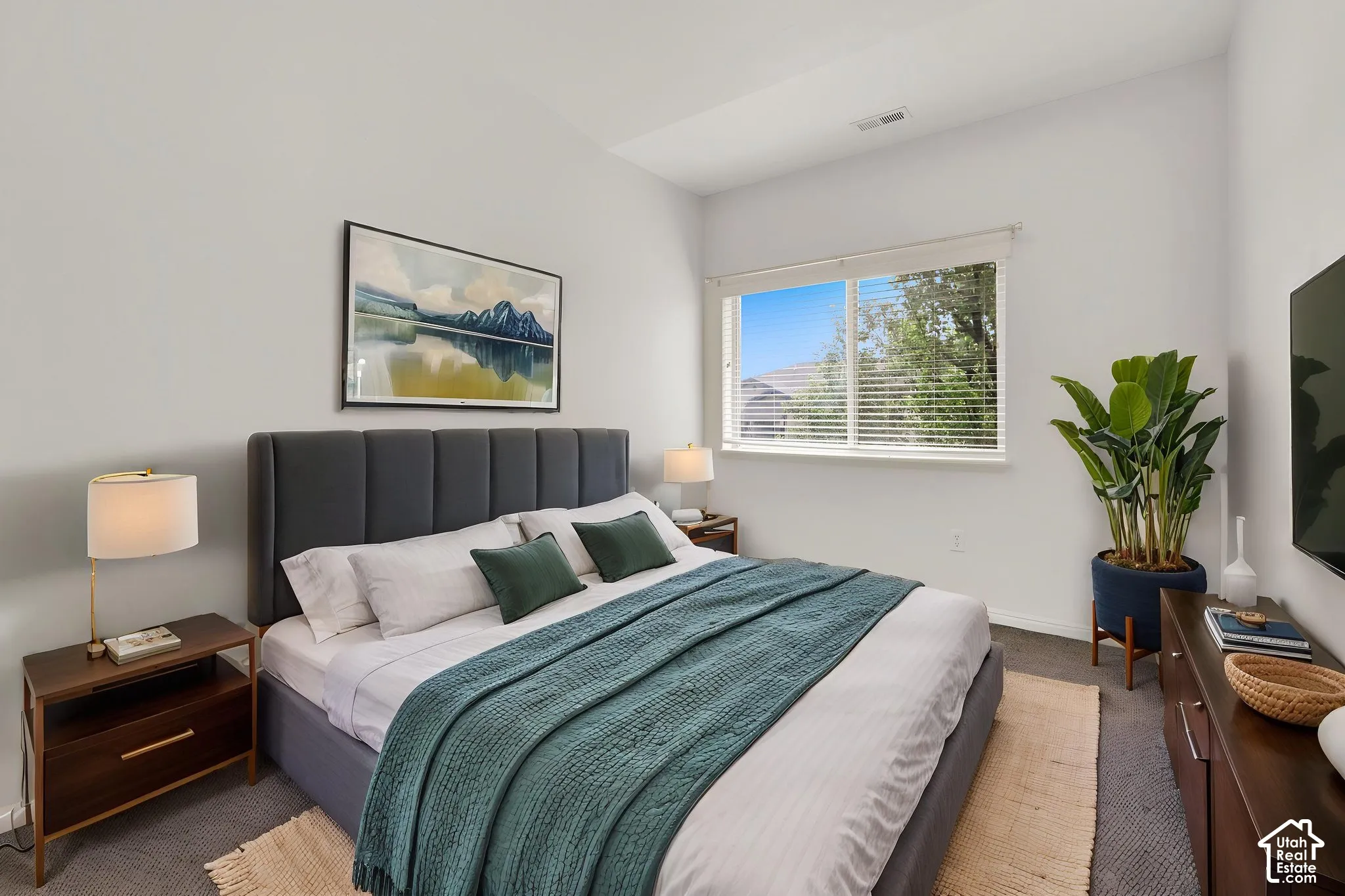 Recessed lighting, large window with blinds, plush gray carpeting, and white walls