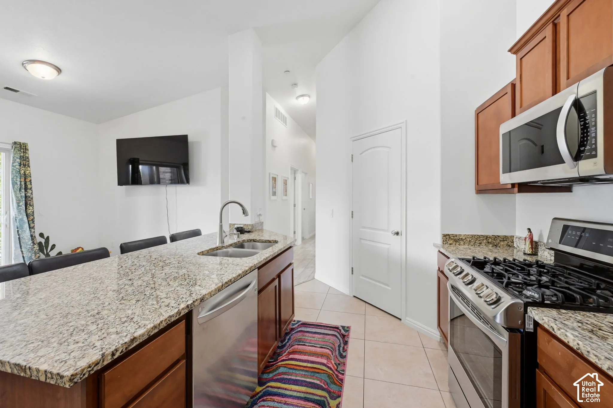 Kitchen featuring a gas range, stainless steel microwave, and wood cabinetry