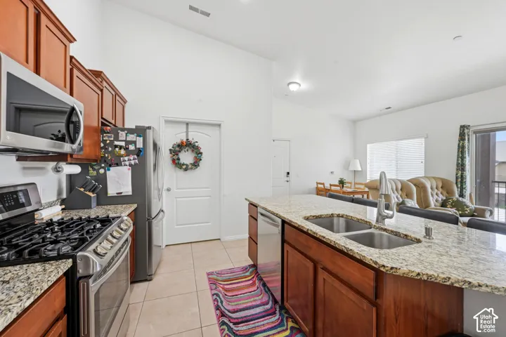 Kitchen featuring wood cabinetry, stainless steel appliances, and light-toned countertops