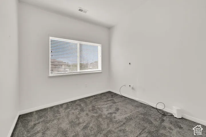 Window with horizontal blinds, neutral wall paint, and gray carpet
