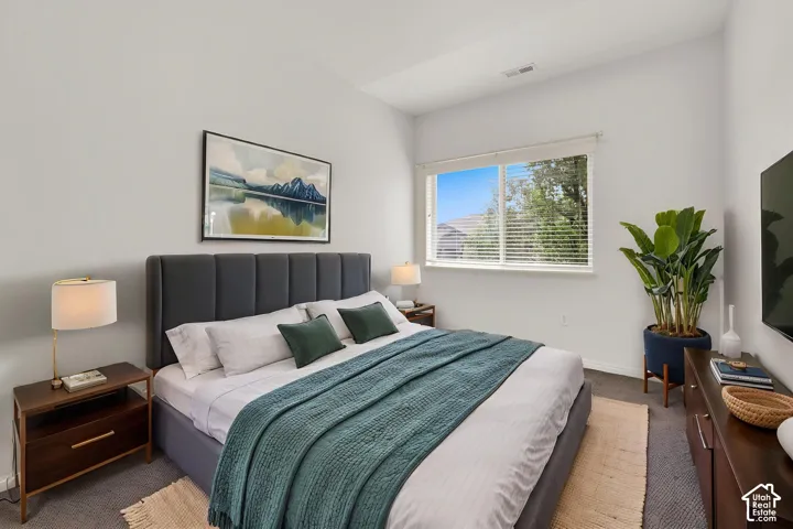 Recessed lighting, large window with blinds, plush gray carpeting, and white walls