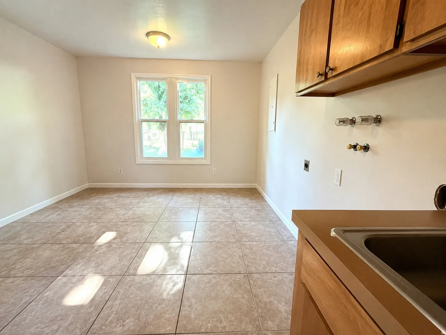 Functional utility room featuring tile flooring, light-toned walls, and a double window