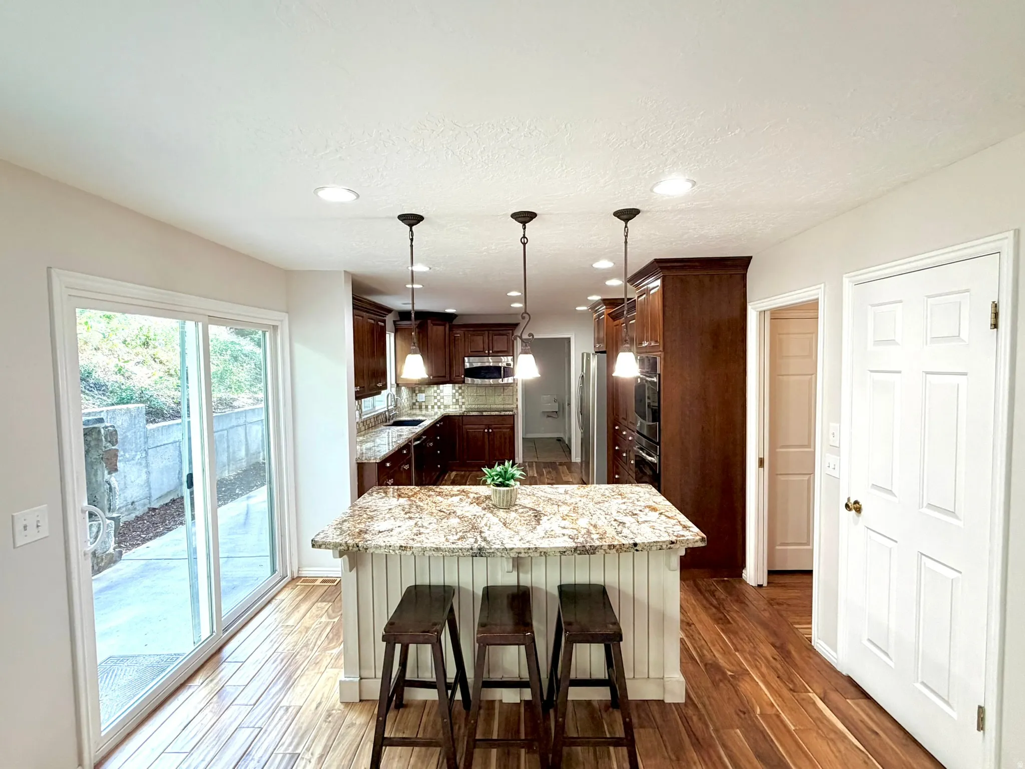 Kitchen featuring an island with a stone countertop and pendant lighting