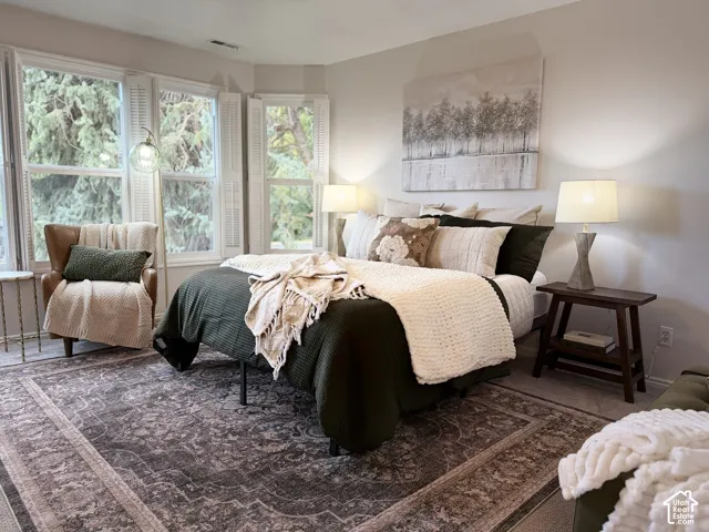 Bay window with plantation shutters, wall-to-wall carpeting, and neutral wall paint
