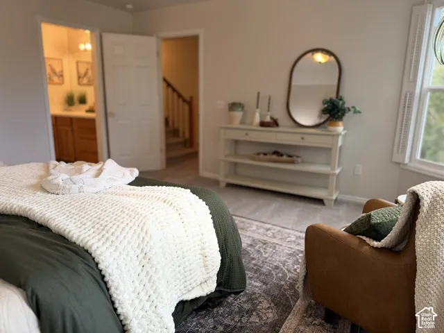 Carpeted flooring, window with shutters, light-colored walls, and a white console table with shelving