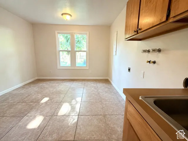 Functional utility room featuring tile flooring, light-toned walls, and a double window