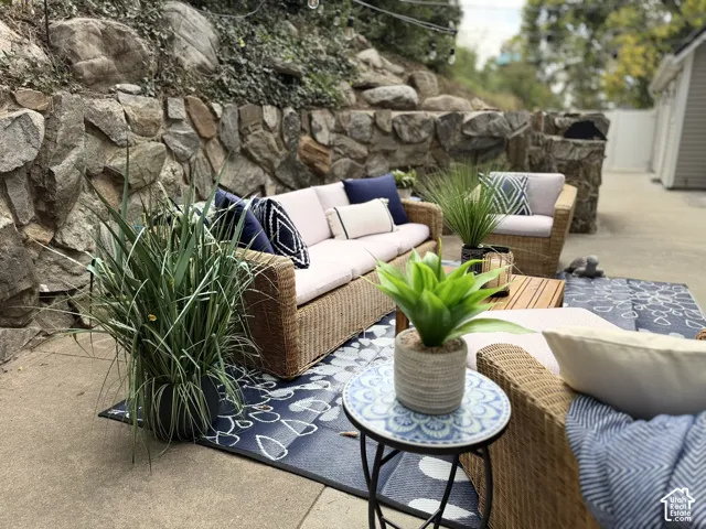 Paved outdoor patio featuring a stone retaining wall