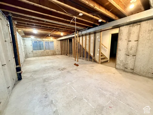Unfinished basement with concrete flooring and exposed ceiling joists
