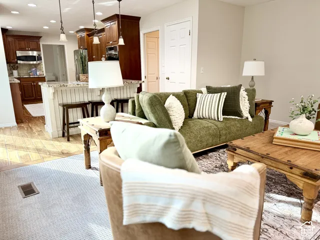Open concept living area with light-toned walls and recessed lighting