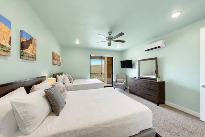Spacious bedroom featuring light-colored walls, carpeted flooring, and recessed lighting