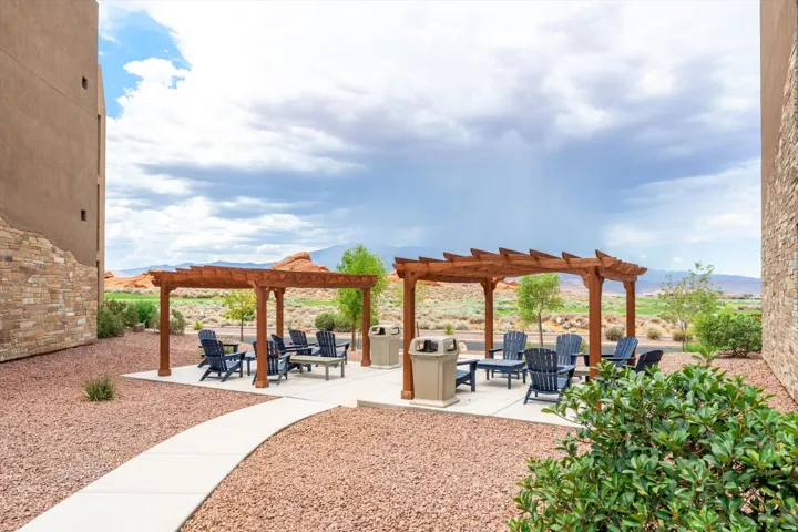 Outdoor pergola-covered seating areas featuring concrete patios and surrounding natural desert landscaping