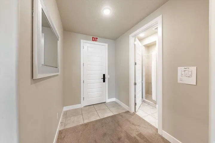 Hallway featuring neutral wall paint, recessed lighting, and a white-framed wall mirror