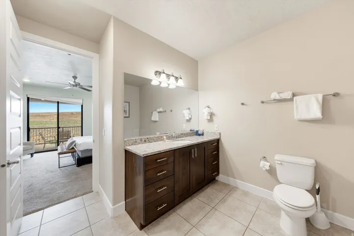 Bathroom featuring a dark wood vanity with a light speckled countertop and a large mirror