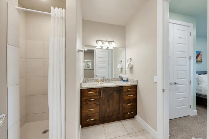 Bathroom featuring a stall shower with tiled walls and a neutral shower curtain