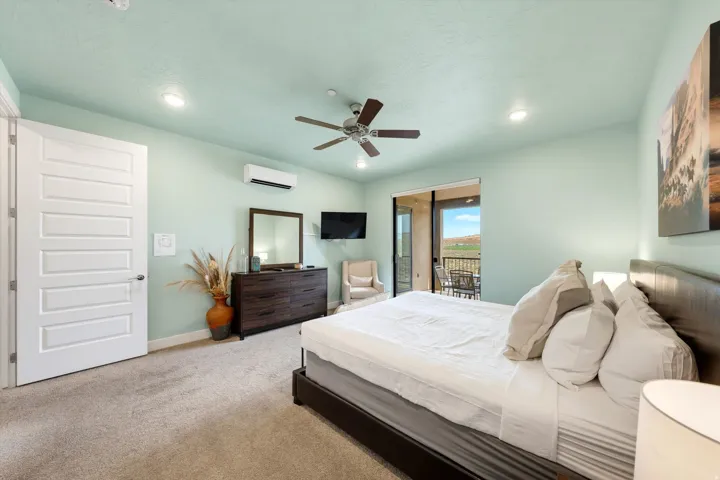 Carpeted bedroom featuring a ceiling fan with light, recessed lighting, and a ductless mini-split unit