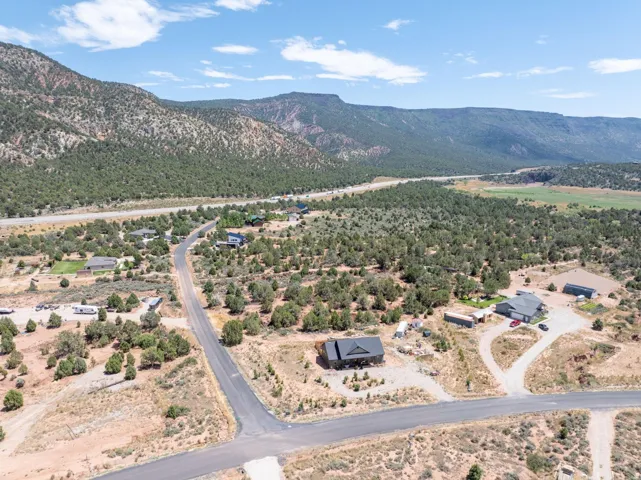 Aerial view showcasing a residential area with varied home styles, surrounded by natural desert landscaping and distant mountains