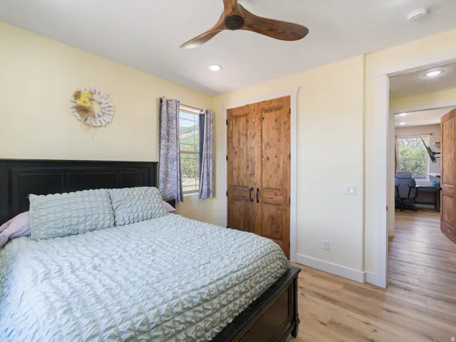 Bedroom featuring wood-finish flooring, a rustic wood ceiling fan, and recessed lighting