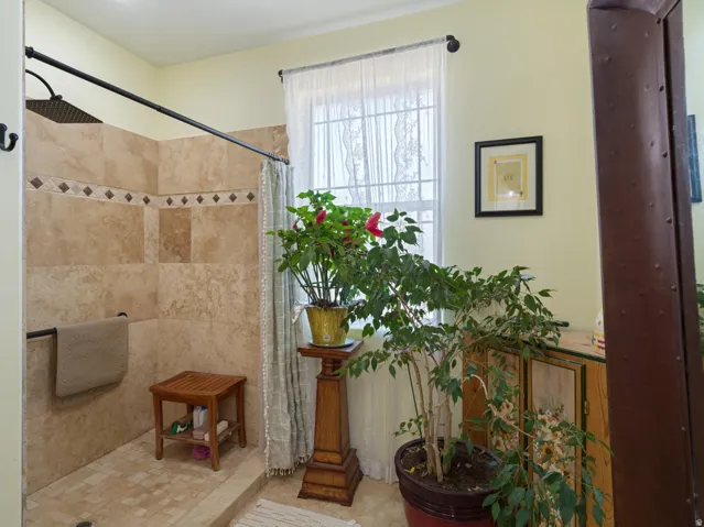 Tiled shower enclosure featuring a decorative accent band and integrated bench