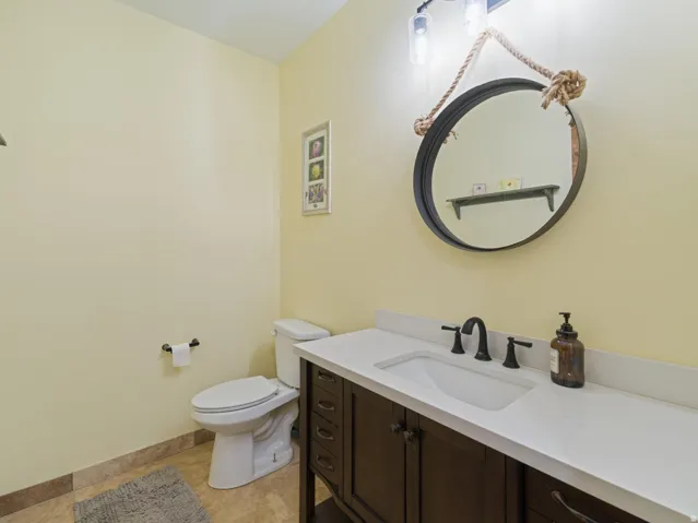 Bathroom featuring a dark wood-finish vanity with a white countertop and integrated sink