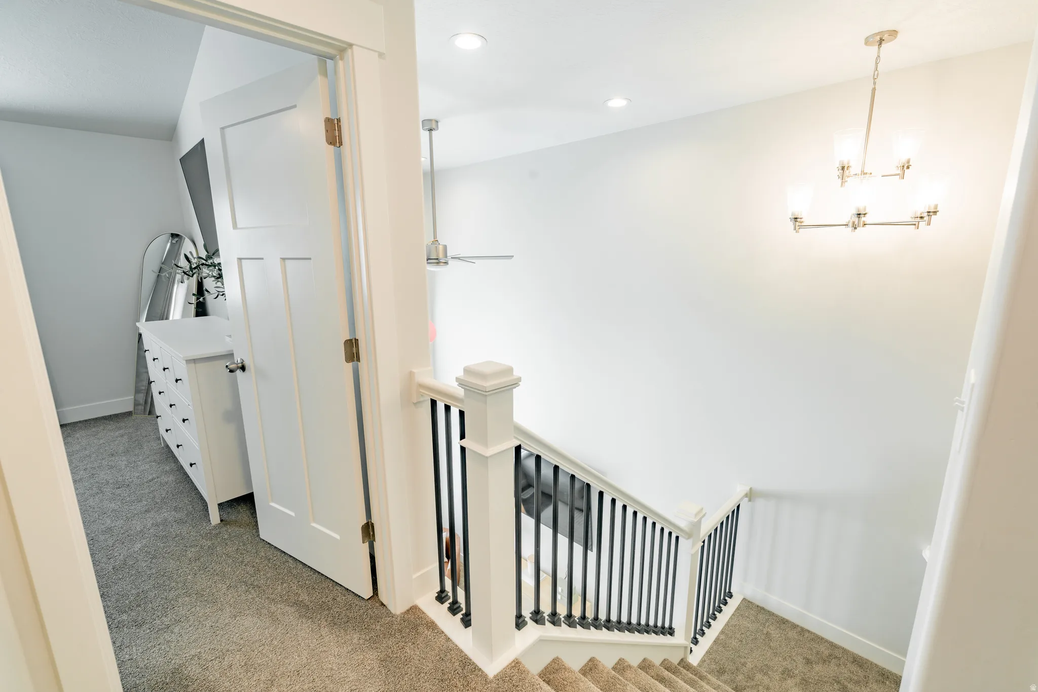 Staircase with white newel posts and black iron balusters