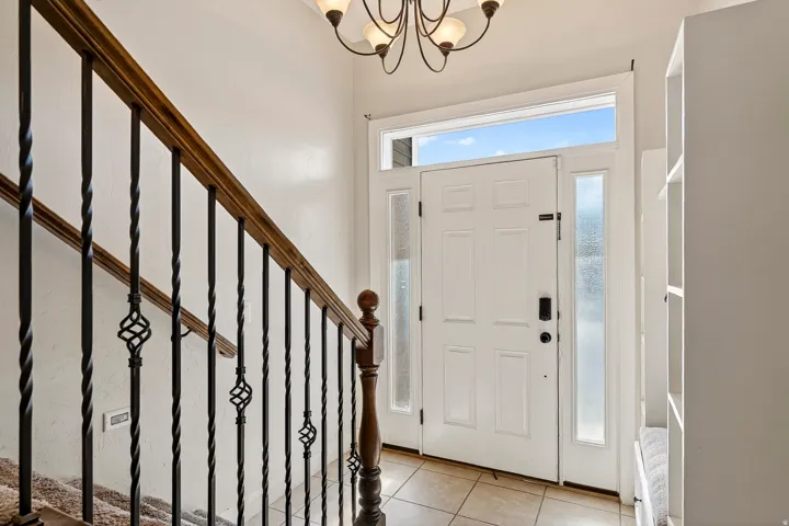 Entryway featuring a white paneled door with frosted sidelights and a transom window