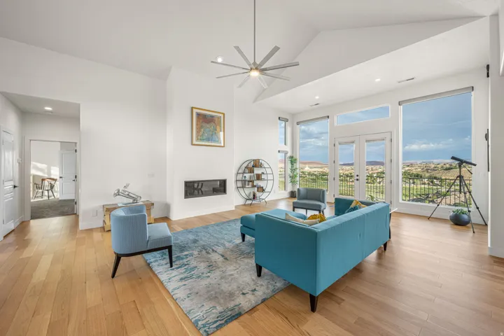 Vaulted ceilings complement the expansive windows and French doors, framing panoramic landscape scenery