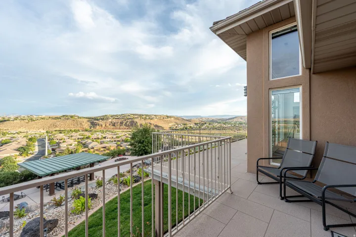 Outdoor patio space with tile flooring and metal railing