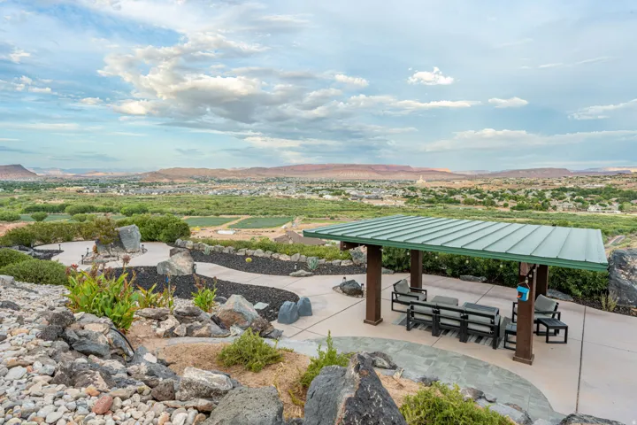 Outdoor living area featuring a covered patio, extensive hardscaping, and a fire pit area