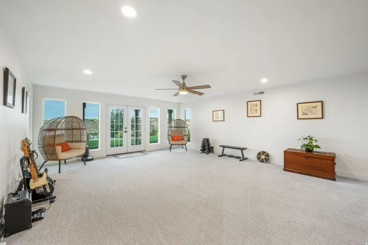 Spacious room featuring light-toned carpeting, ample recessed lighting, and a ceiling fan