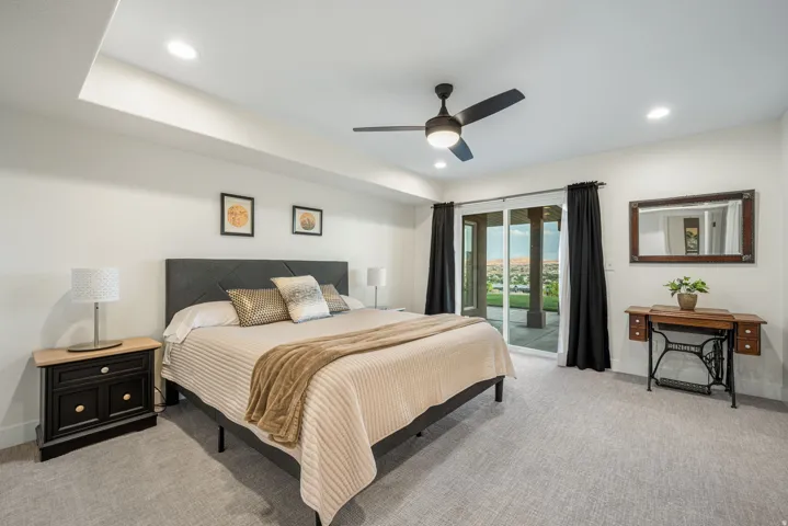 Recessed lighting illuminates a spacious room featuring textured carpet flooring and a ceiling fan with integrated lighting