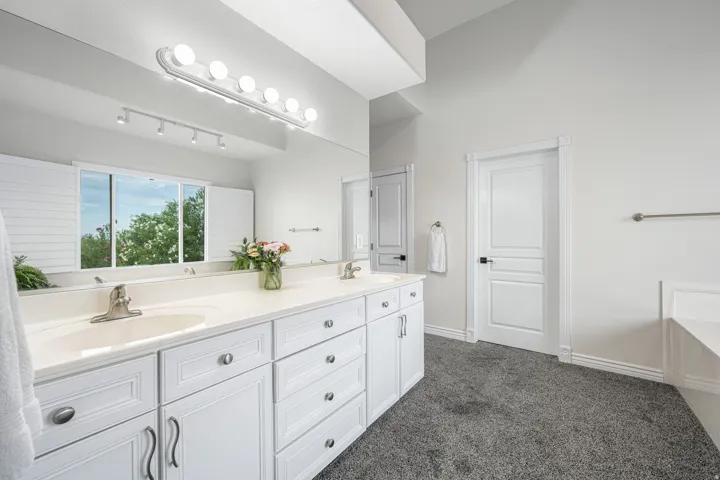Dual vanity with white cabinetry, light-toned countertops, and dual undermount sinks