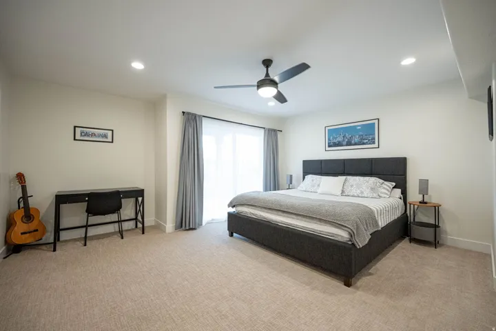 Spacious room featuring neutral carpeting, recessed lighting, and a contemporary ceiling fan