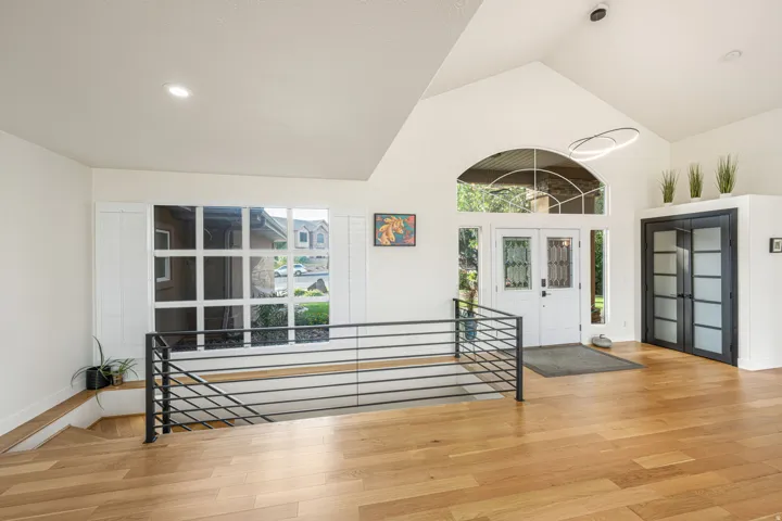 Vaulted entry featuring a double front door with sidelights and an arched transom window