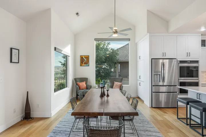 Vaulted ceiling dining area with wood-finish flooring