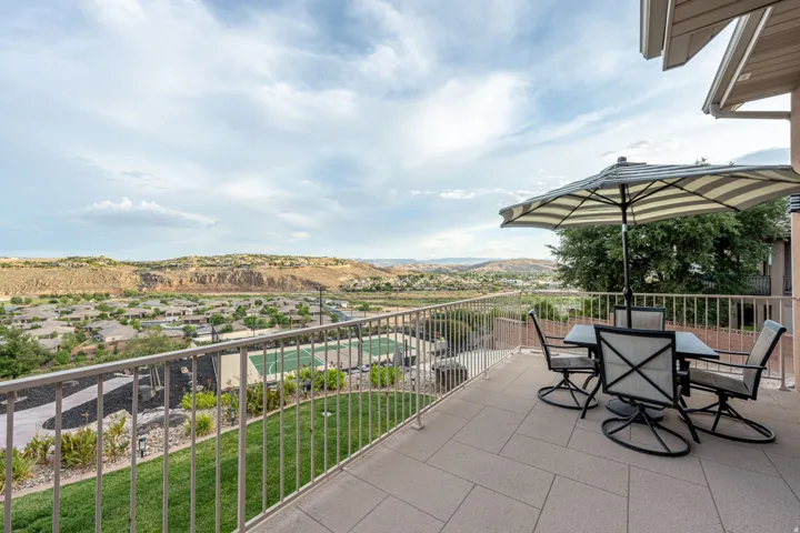 Spacious outdoor patio featuring tiled flooring and a metal railing