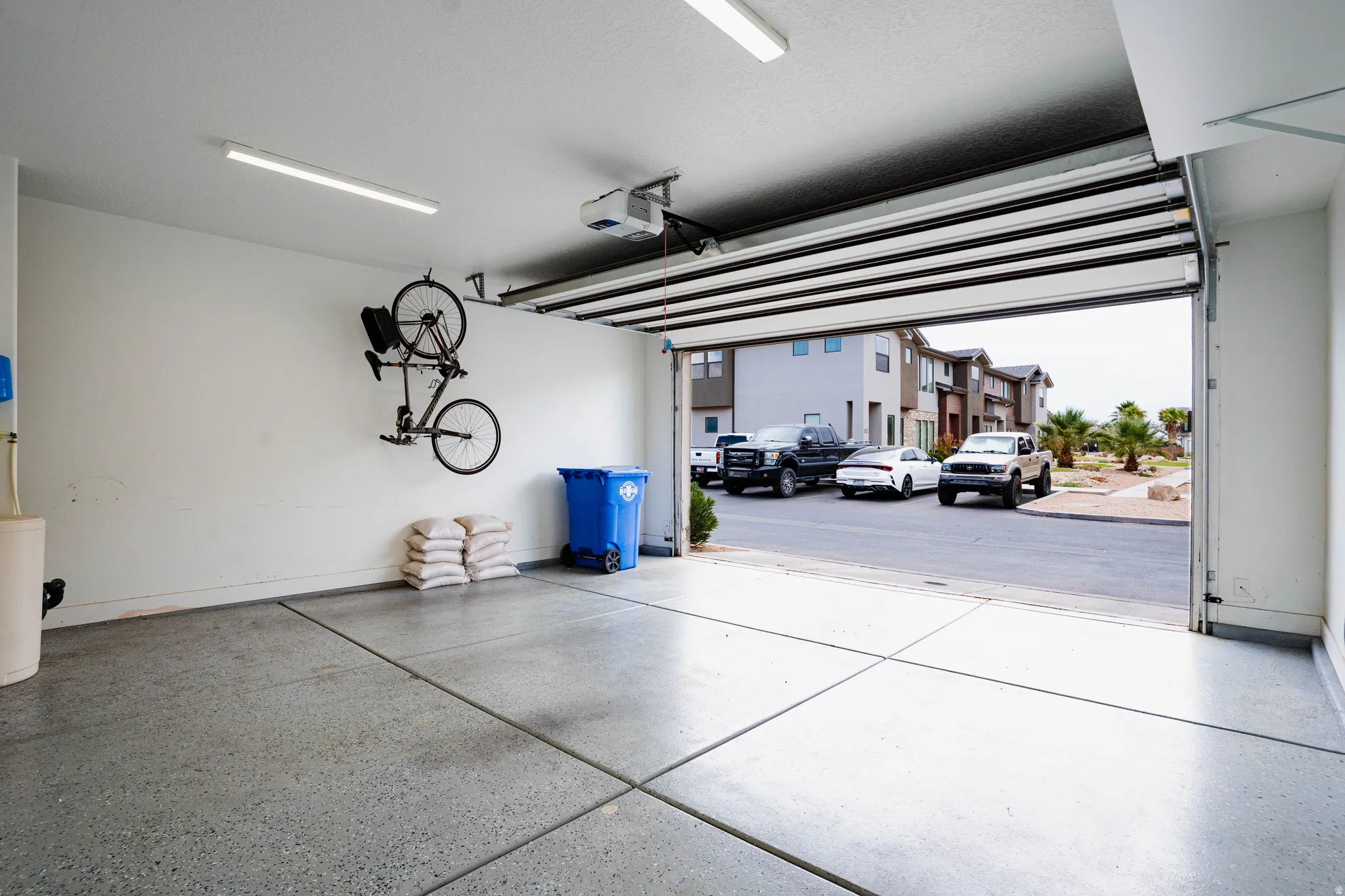 Integrated two-car garage featuring an automatic overhead door, concrete flooring, and built-in overhead lighting