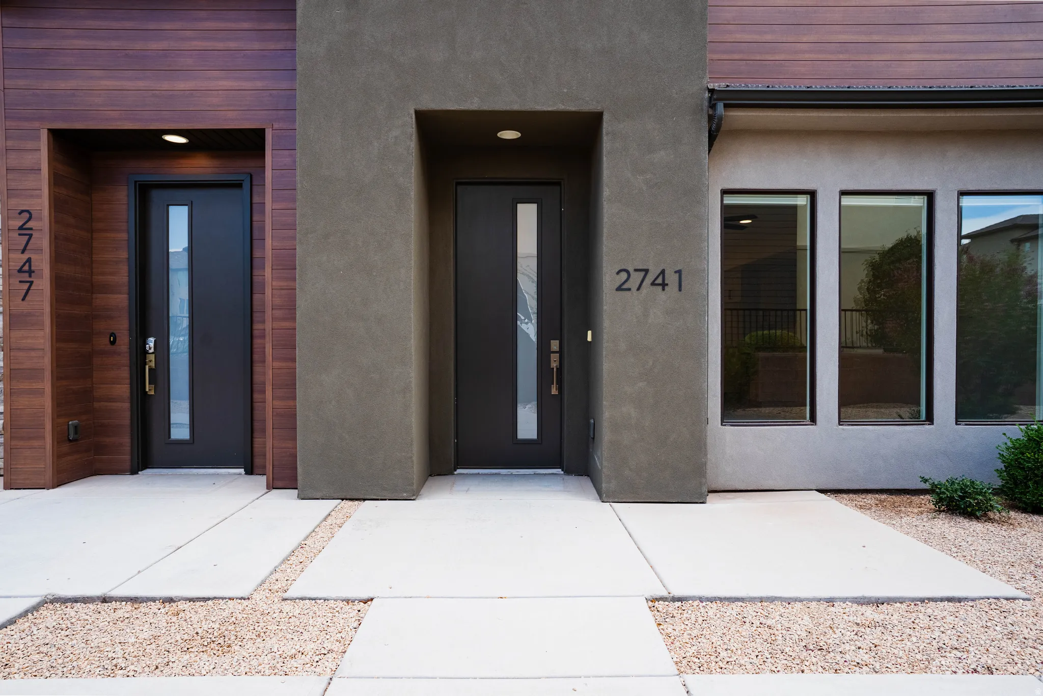 Modern facade featuring wood-finish siding and stucco accents