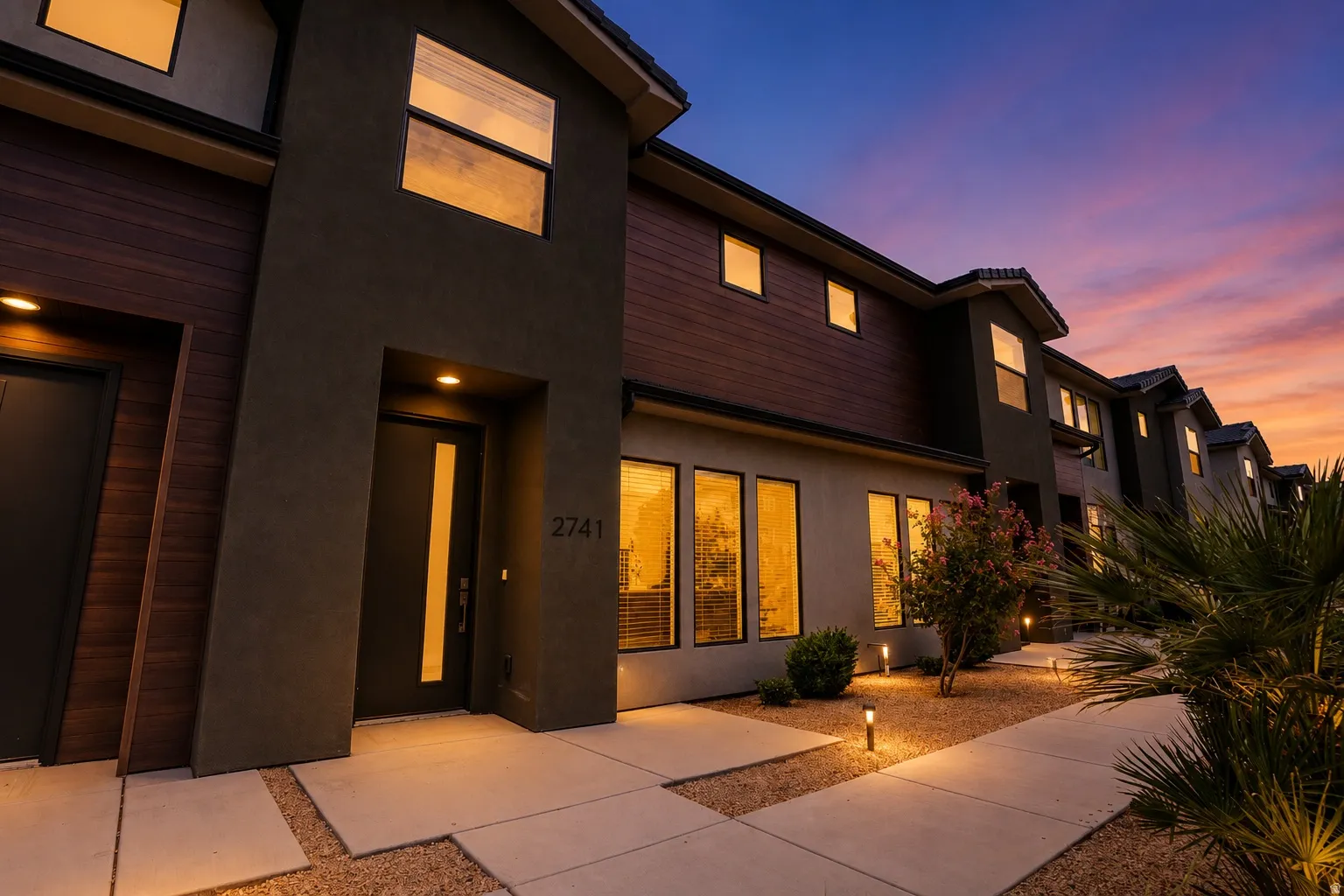 Modern exterior featuring dark stucco and wood-finish siding